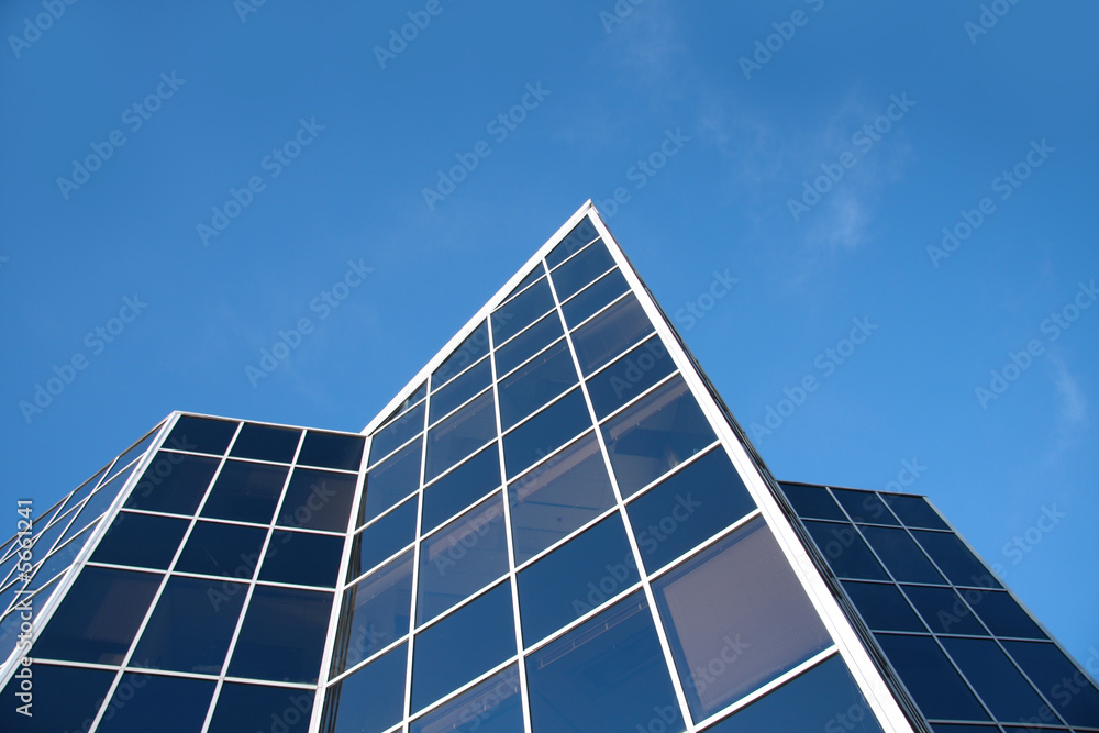 明亮的蓝天衬托下的现代化新办公楼。