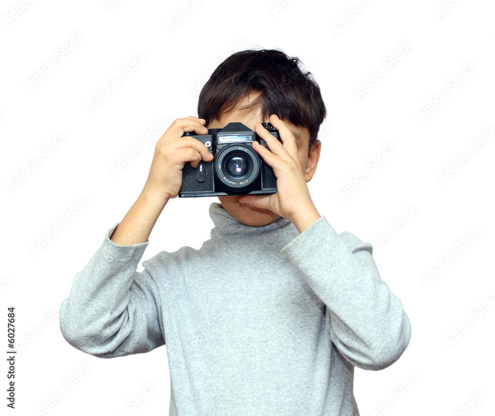 亚洲男孩用隔离在白色的黑色单反相机拍照