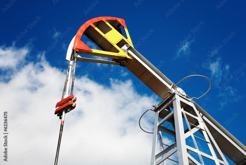 Oil pump jack against blue sky background