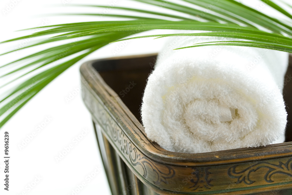 木制碗中的水疗浴巾和棕榈叶