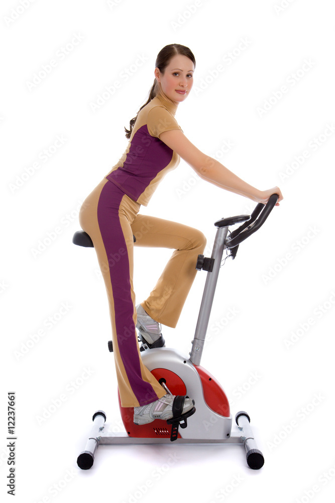 有魅力的女人骑着固定自行车健身
