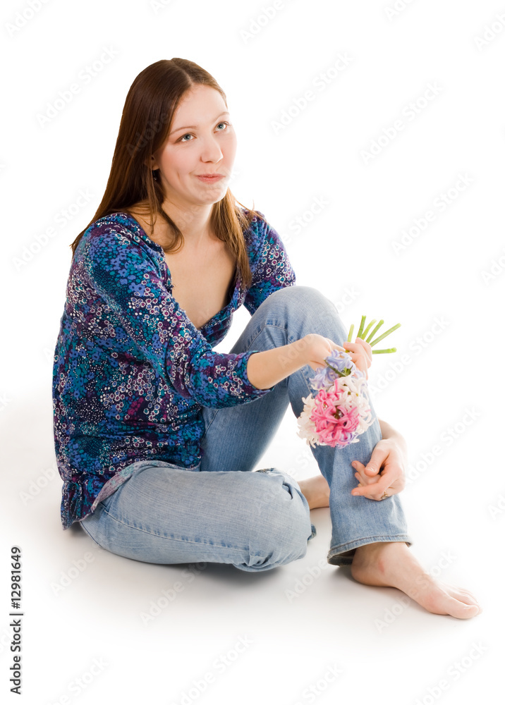 困惑的女人坐在花朵上，手里拿着花