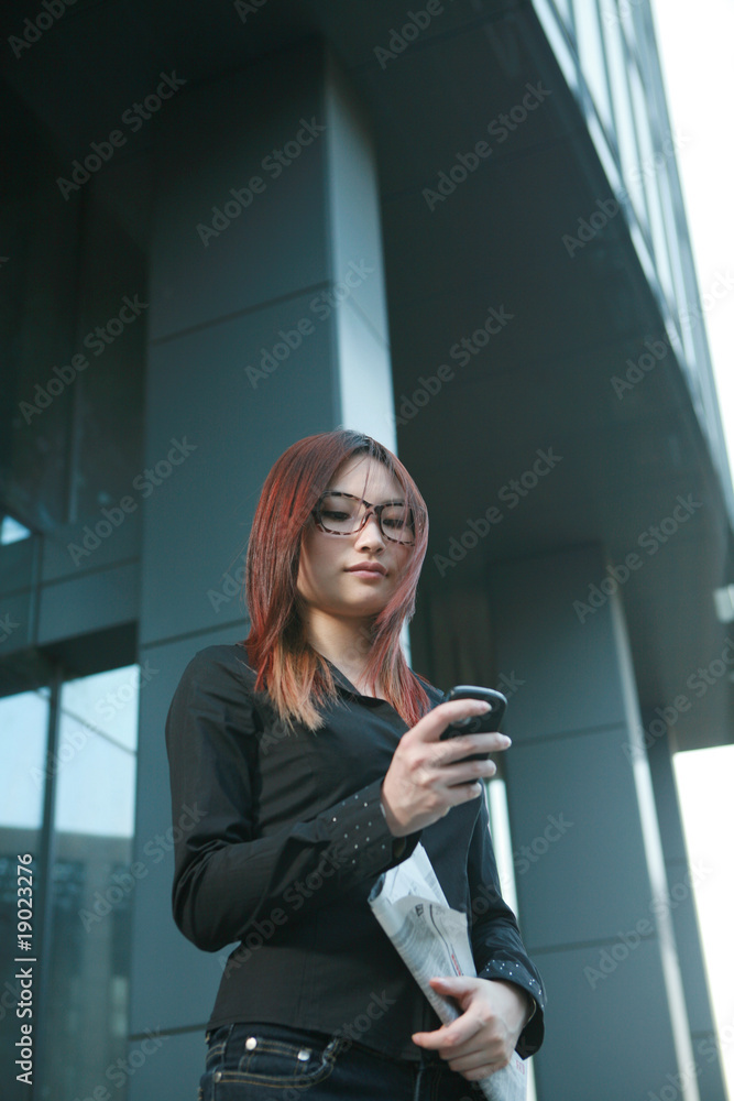 businesswoman holding newspaper and mobile phone