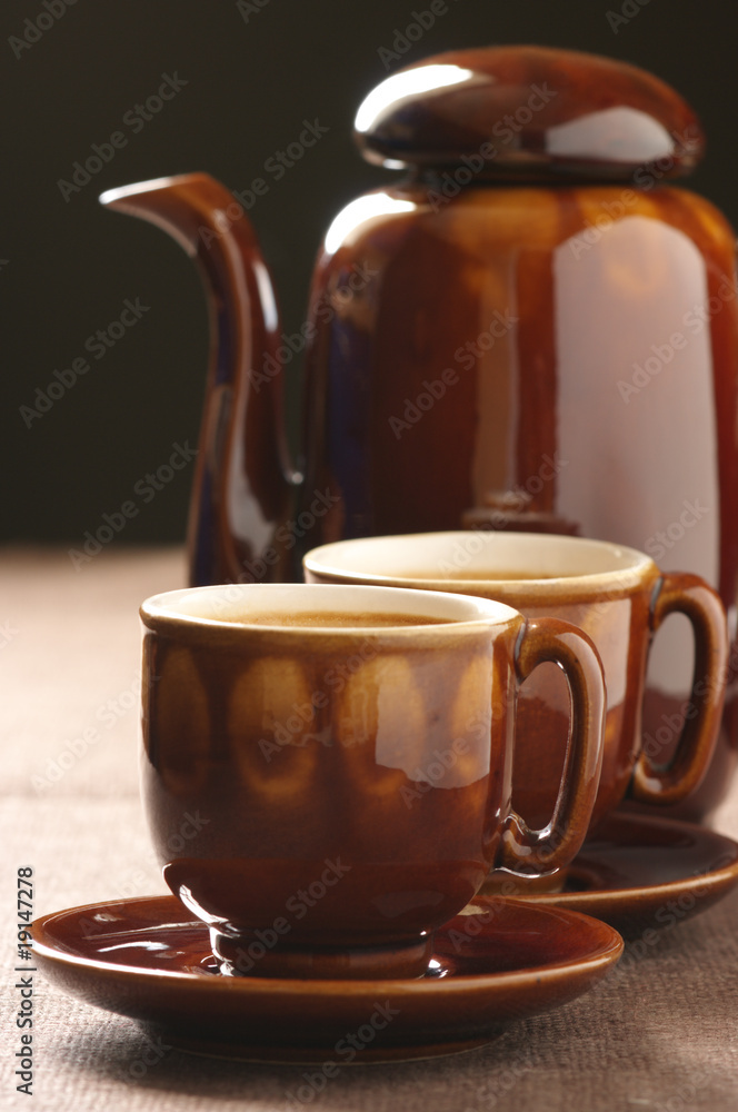 Cups of cappuccino and coffee pot