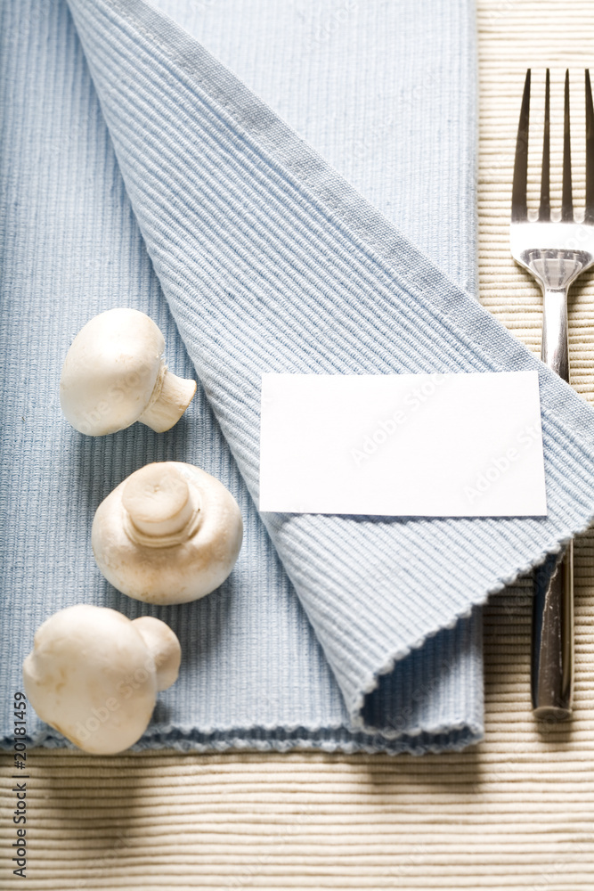叉子和蘑菇放在蓝色餐巾上