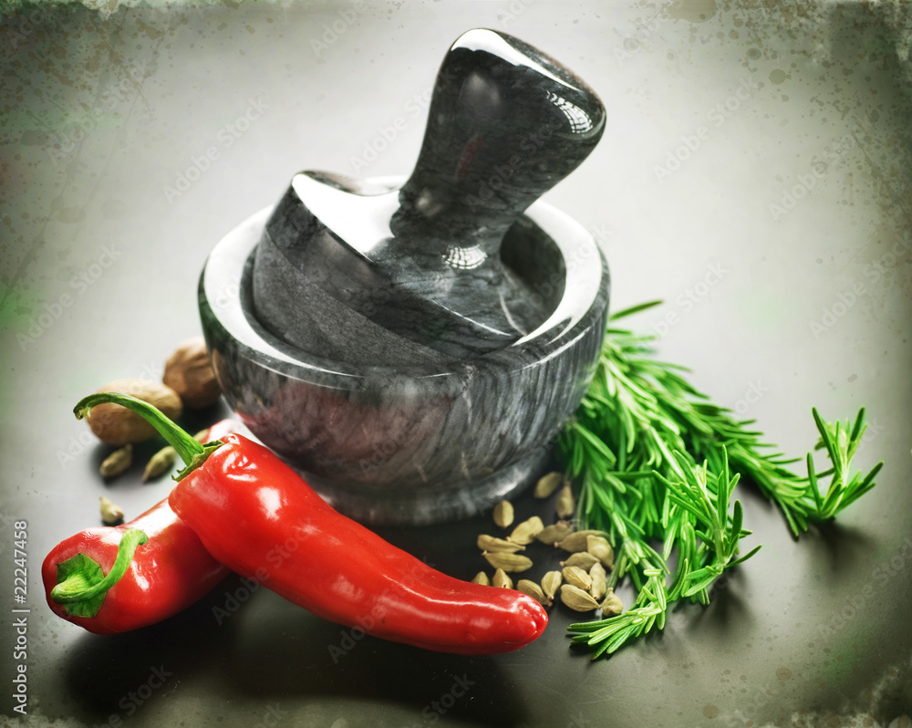 Mortar with pestle and Herbs.Over black background