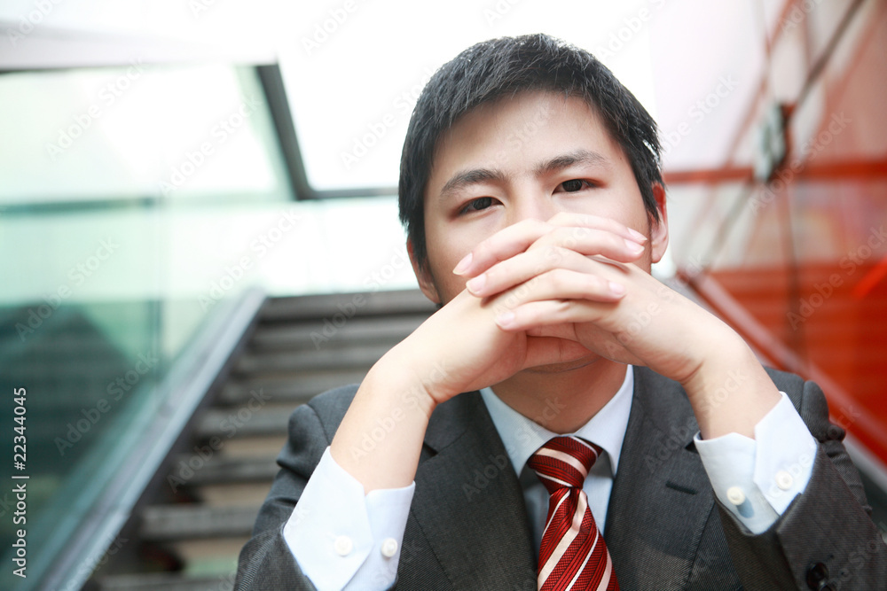 一个年轻的亚洲商人在户外思考一些事情