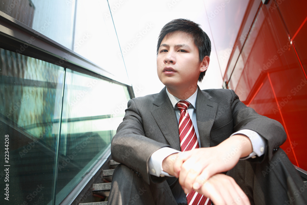 一个年轻的亚洲商人正在考虑户外活动