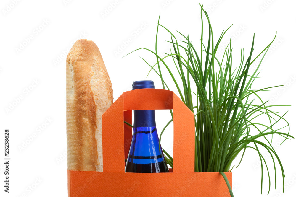 装有面包、瓶子和绿色植物的购物袋