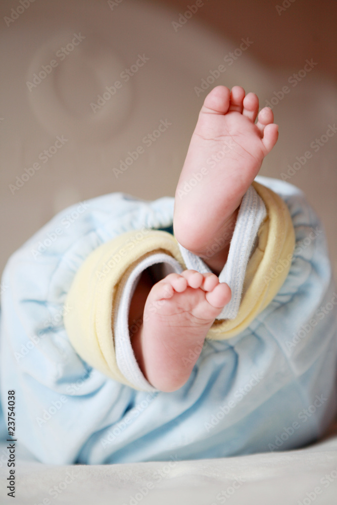 可爱的小婴儿躺在床上，双脚伸展