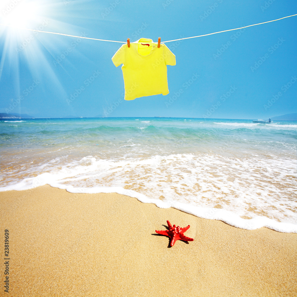 黄色T恤挂在海滩上的绳子上