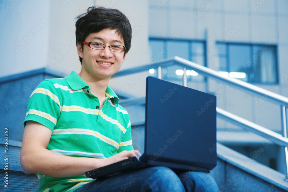 asian male student with laptop