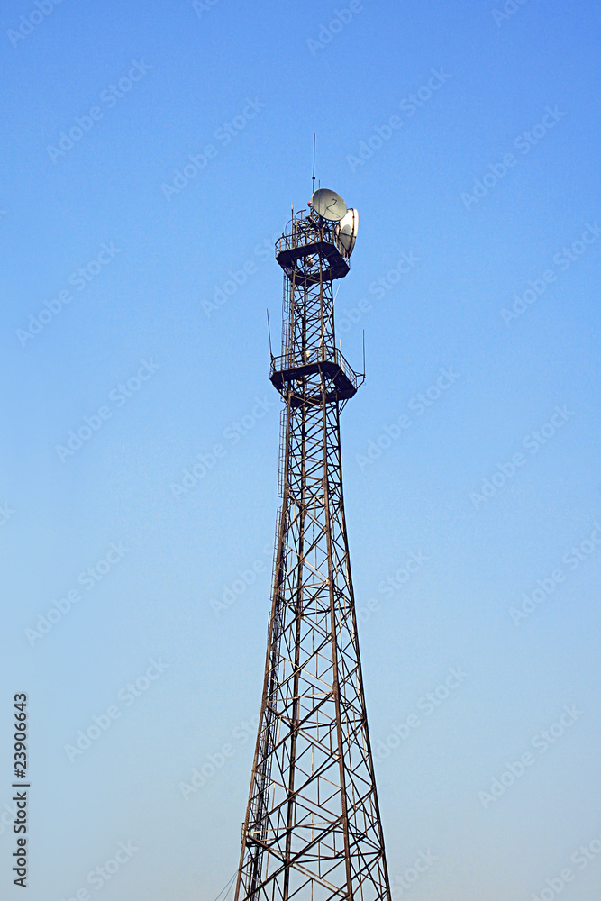 Communication tower over a deep blue sky.