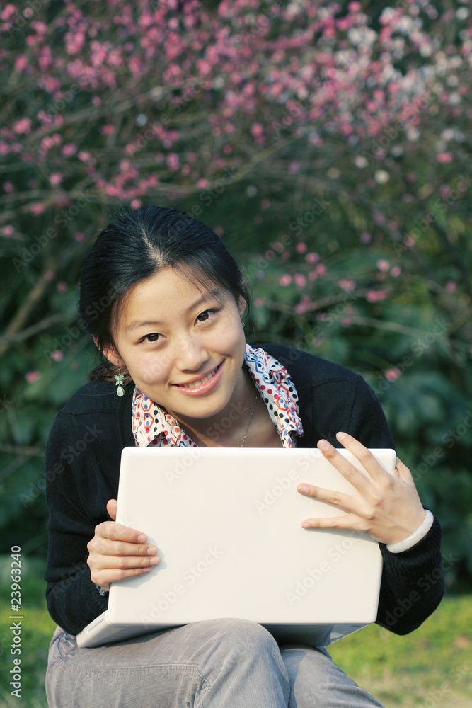 一位带着笔记本电脑的亚洲美女