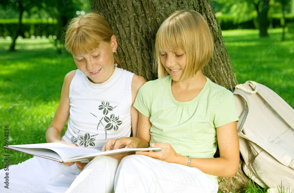 两个女孩在户外看书