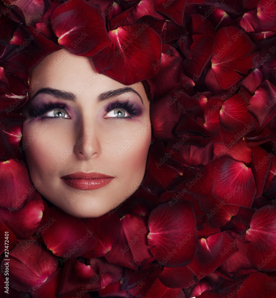 美丽的女人脸和玫瑰花瓣。完美的皮肤