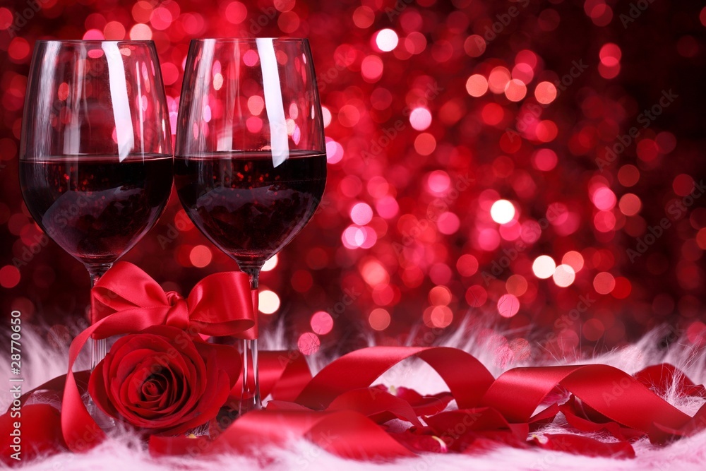 两杯葡萄酒，抽象背景上的玫瑰和缎带。