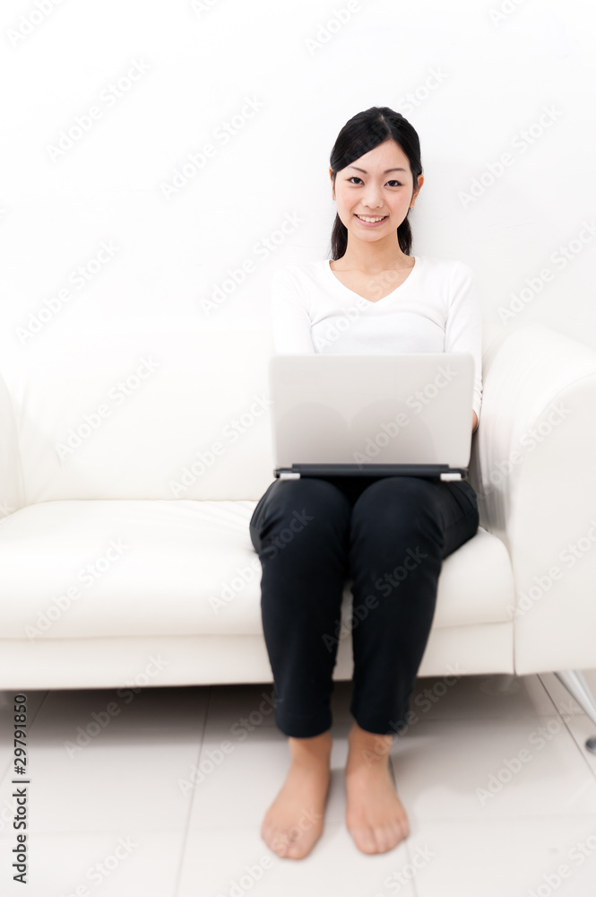 beautiful asian woman using laptop on the sofa