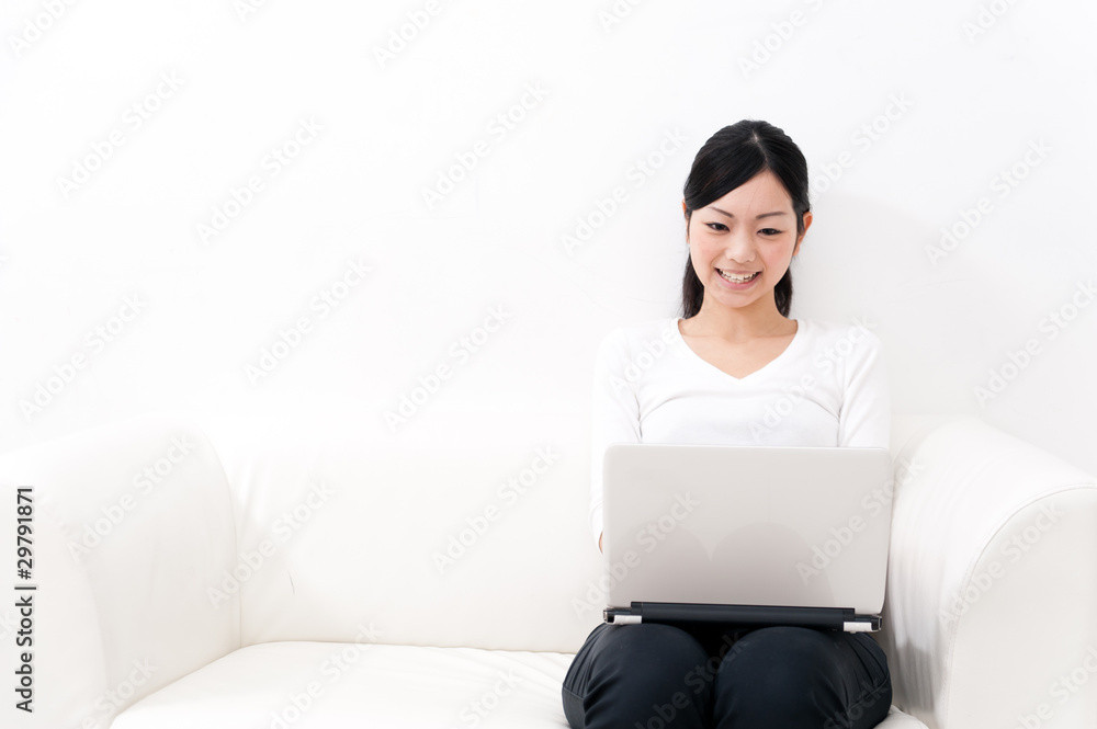 亚洲美女在沙发上用笔记本电脑