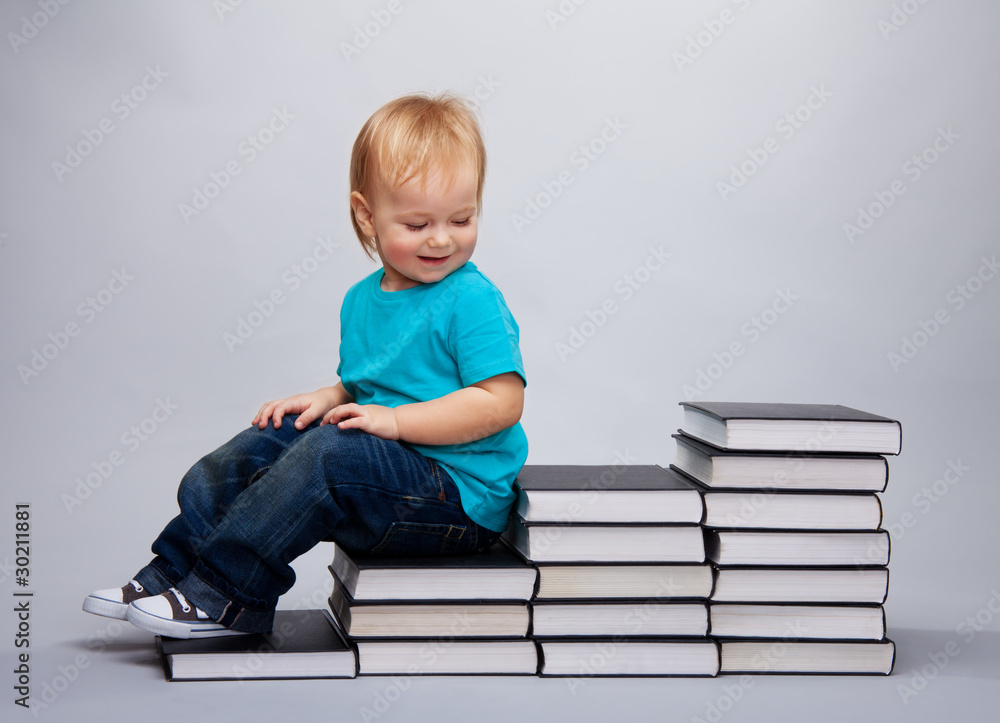 孩子坐在书做的台阶上