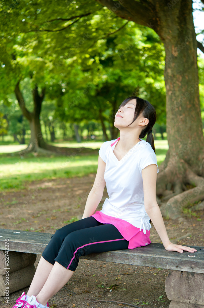 美丽的亚洲女人在公园放松