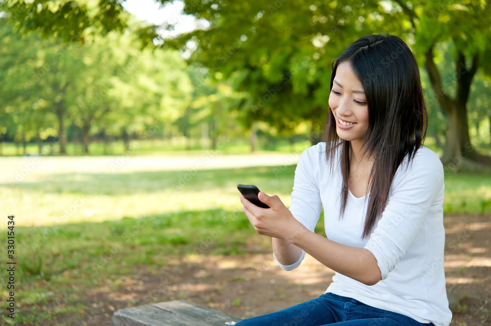 亚洲美女在公园里使用智能手机