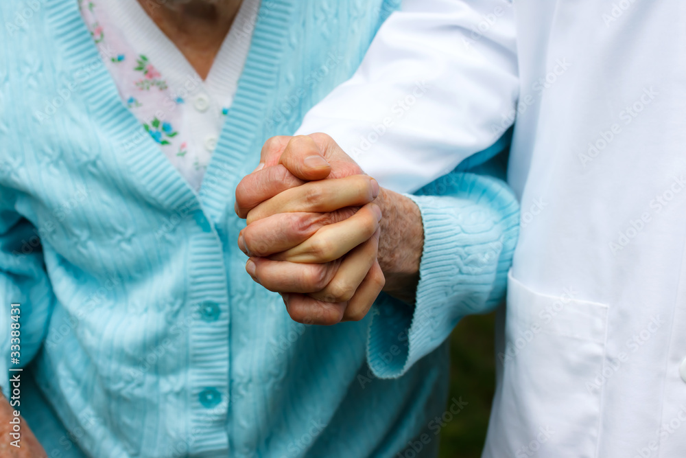 Senior lady with doctor, holding hands
