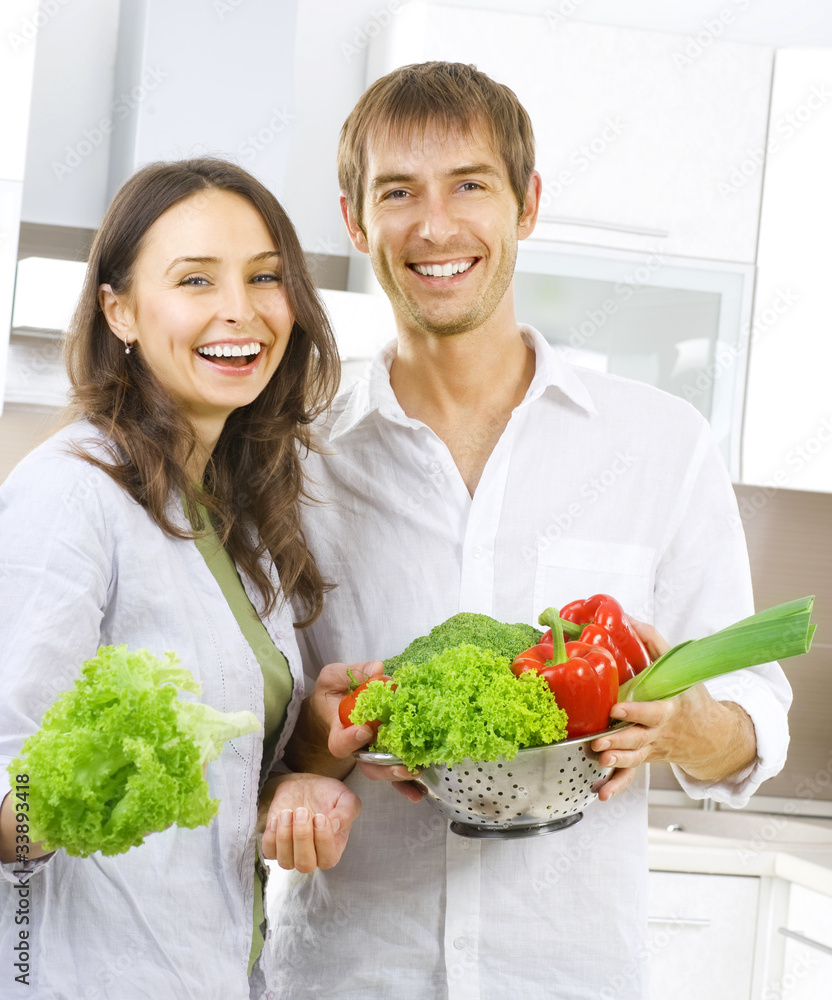 年轻幸福的夫妇在家里的厨房一起做饭。节食