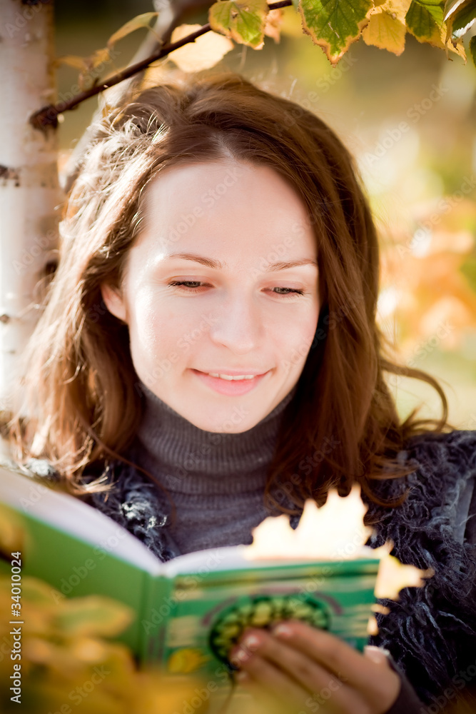微笑的女人在秋天读书