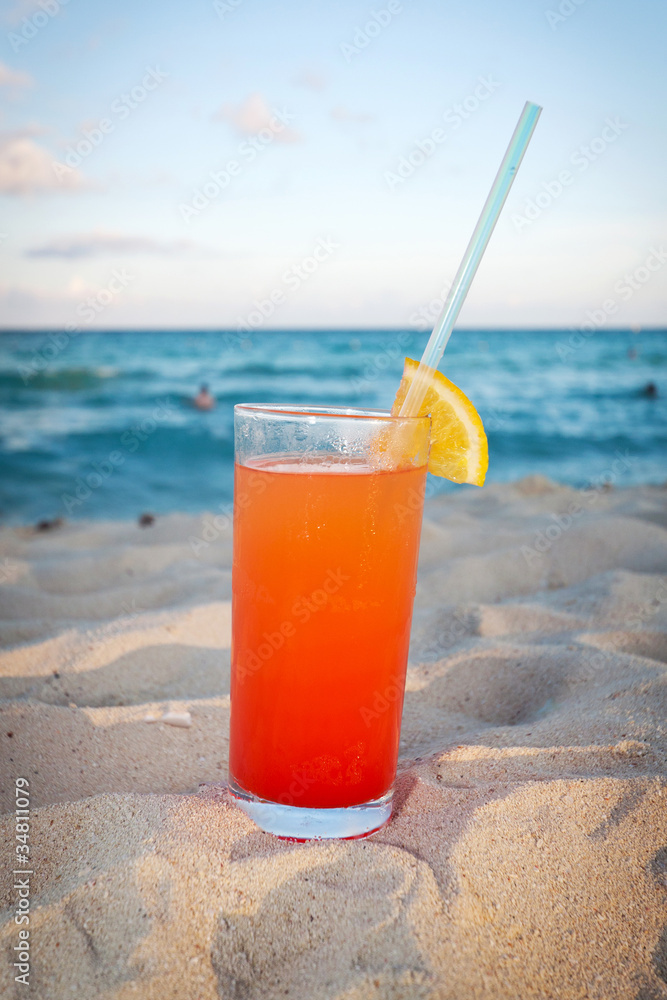 日落时加勒比海海滩上的龙舌兰日出饮料