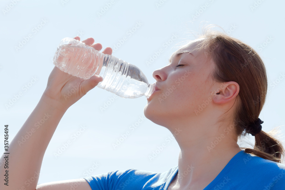 年轻女子用奶瓶喝水