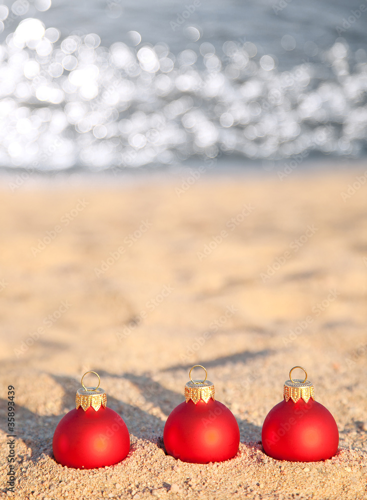 海上海岸的三个红色圣诞球