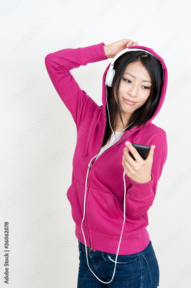 迷人的亚洲女人在听音乐