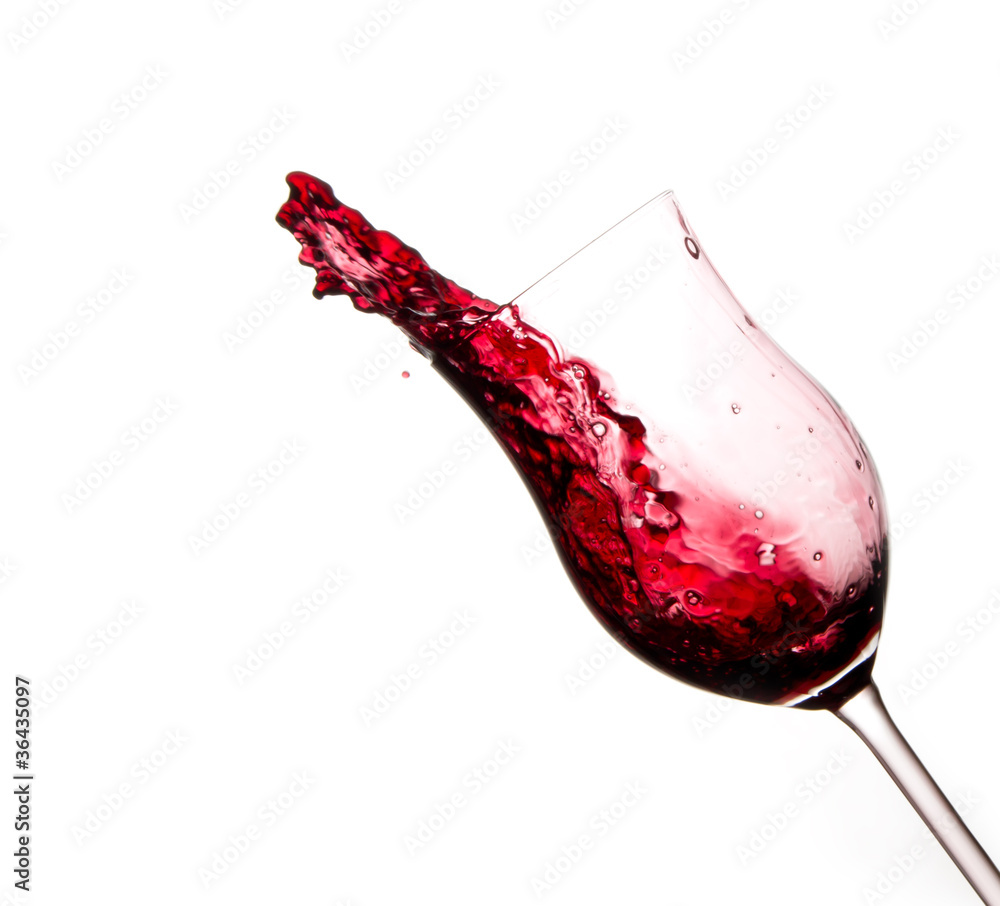 红酒从玻璃中飞溅出来，在白色背景上隔离