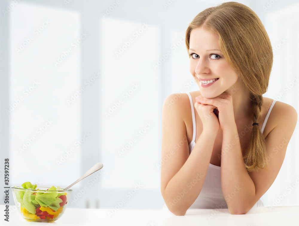 吃蔬菜沙拉的漂亮年轻女人