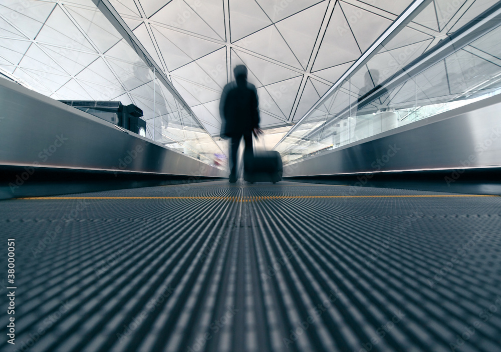 一名男子冲过机场的自动扶梯