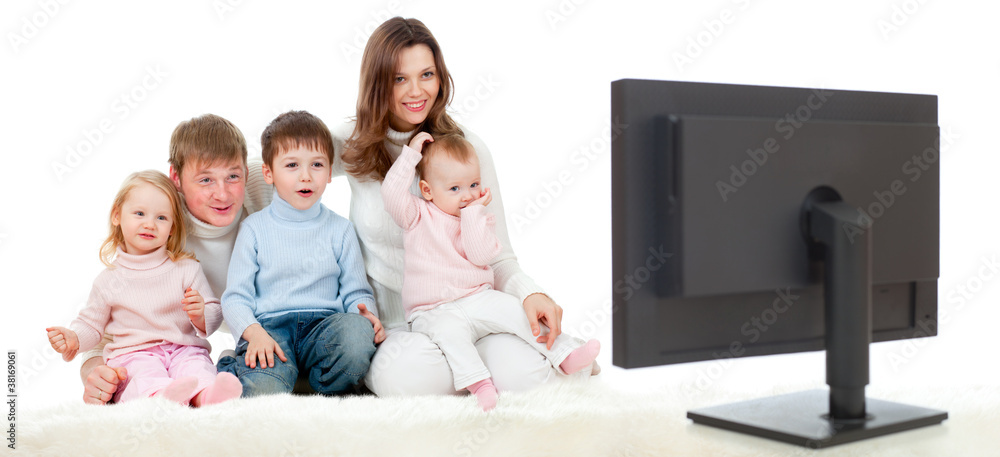 快乐的一家人坐在地板上和gr一起看电视或显示器