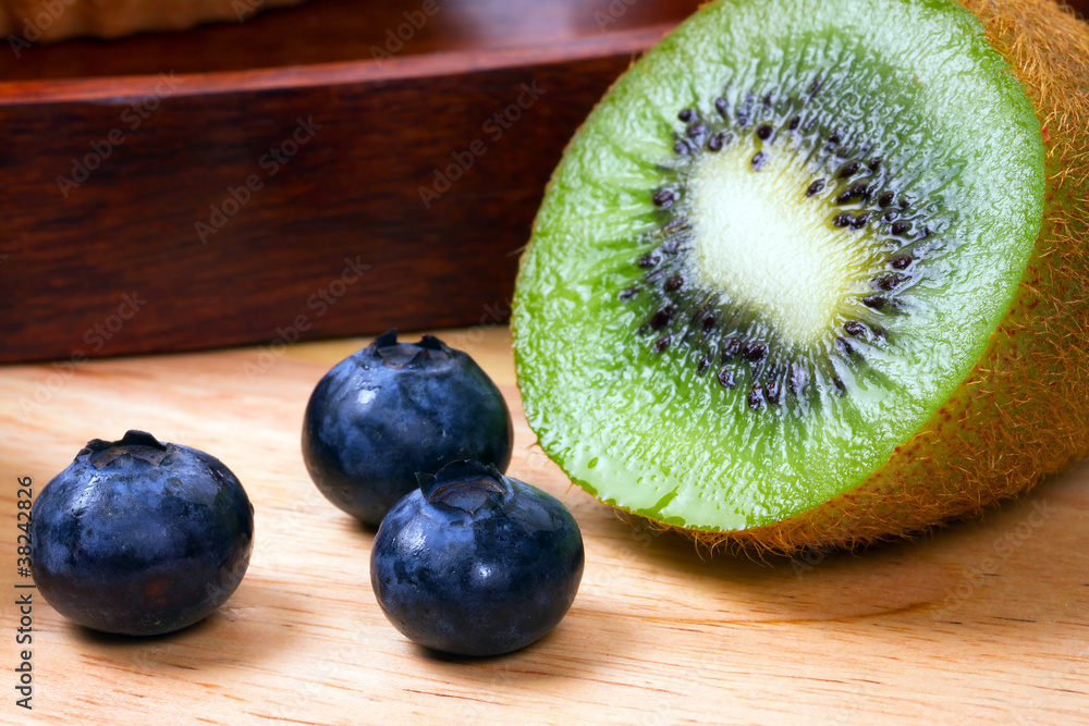 厨房木板上的蓝莓和一半猕猴桃