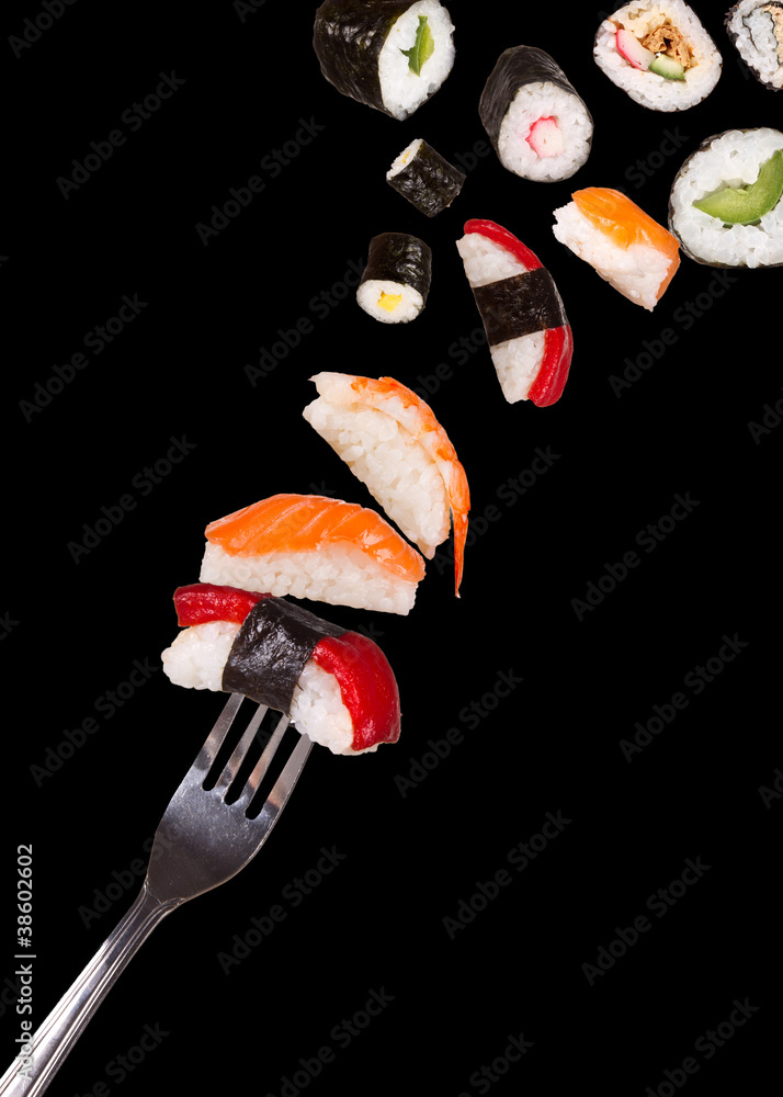寿司碎片落在叉子上，在黑色背景上隔离