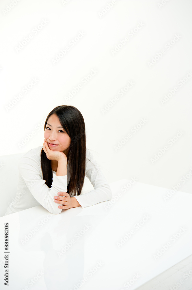 坐在白色房间里的迷人亚洲女人