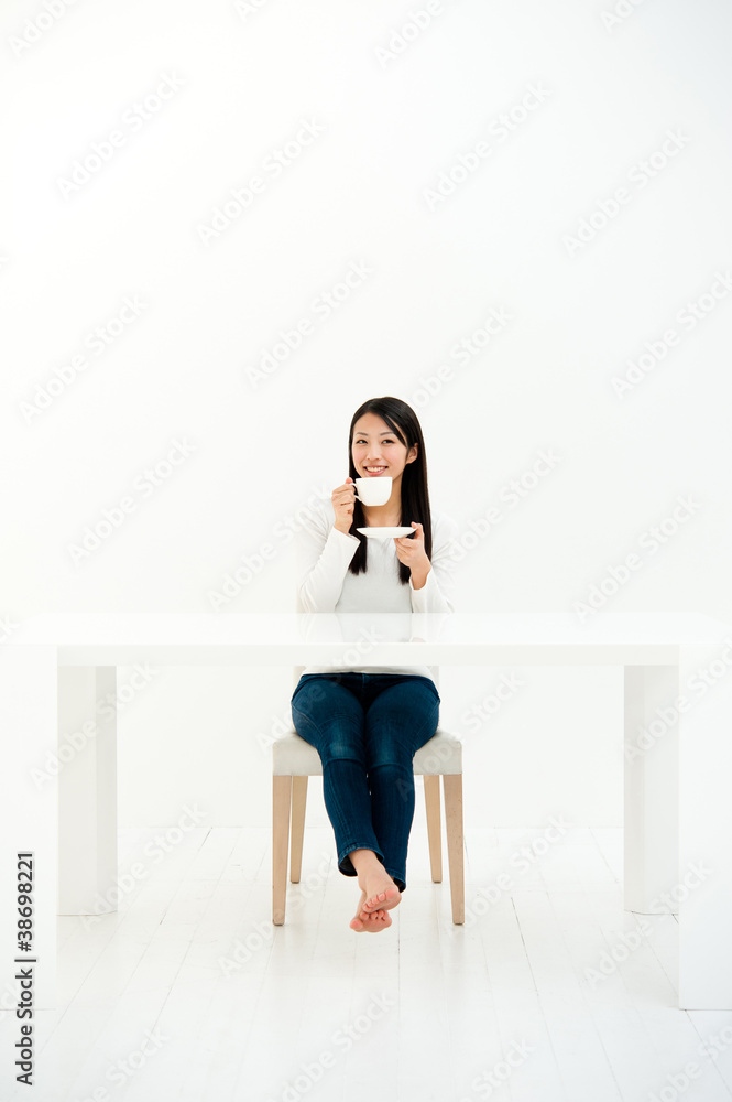 漂亮的亚洲女人在白色房间里喝酒