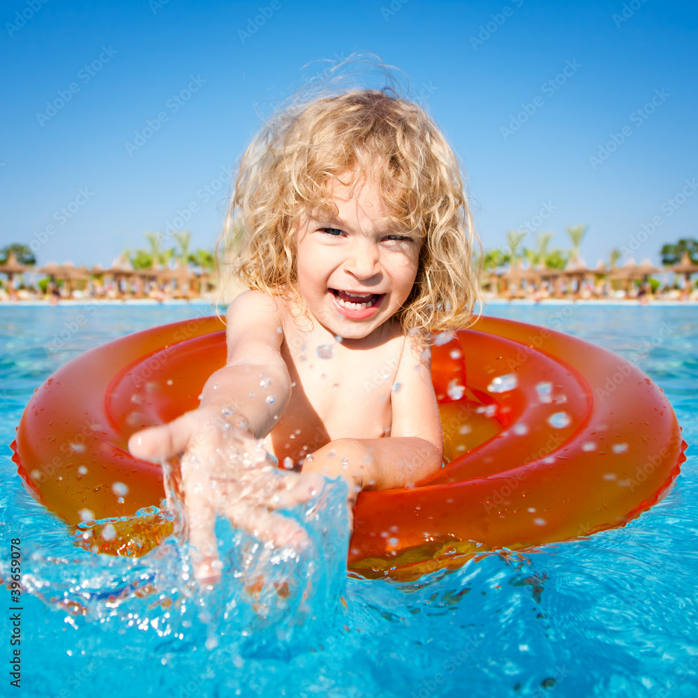 Happy child playing in blue water