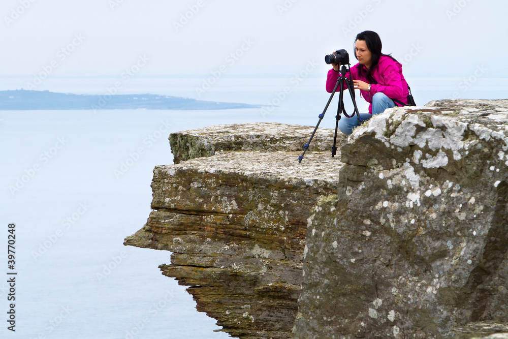 爱尔兰悬崖风景中的女摄影师