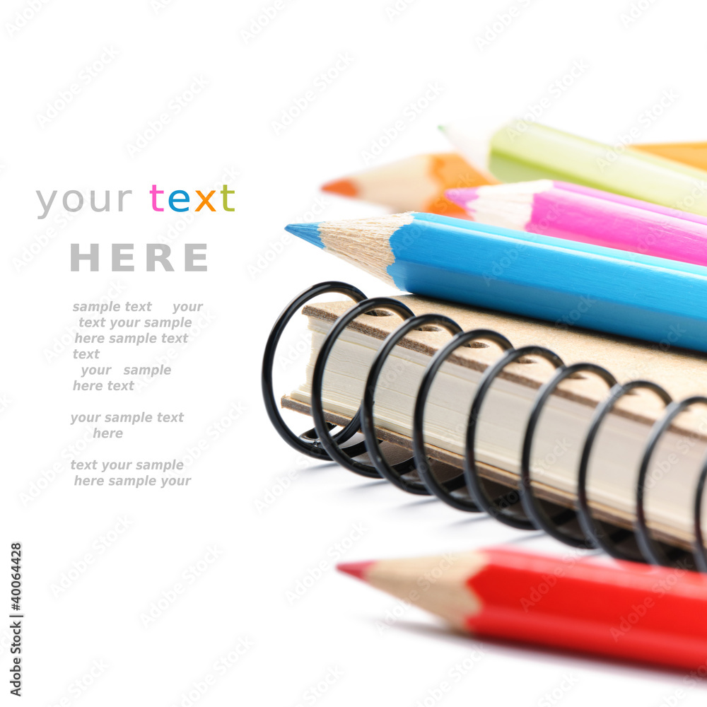 彩色铅笔和笔记本被隔离在白色之上