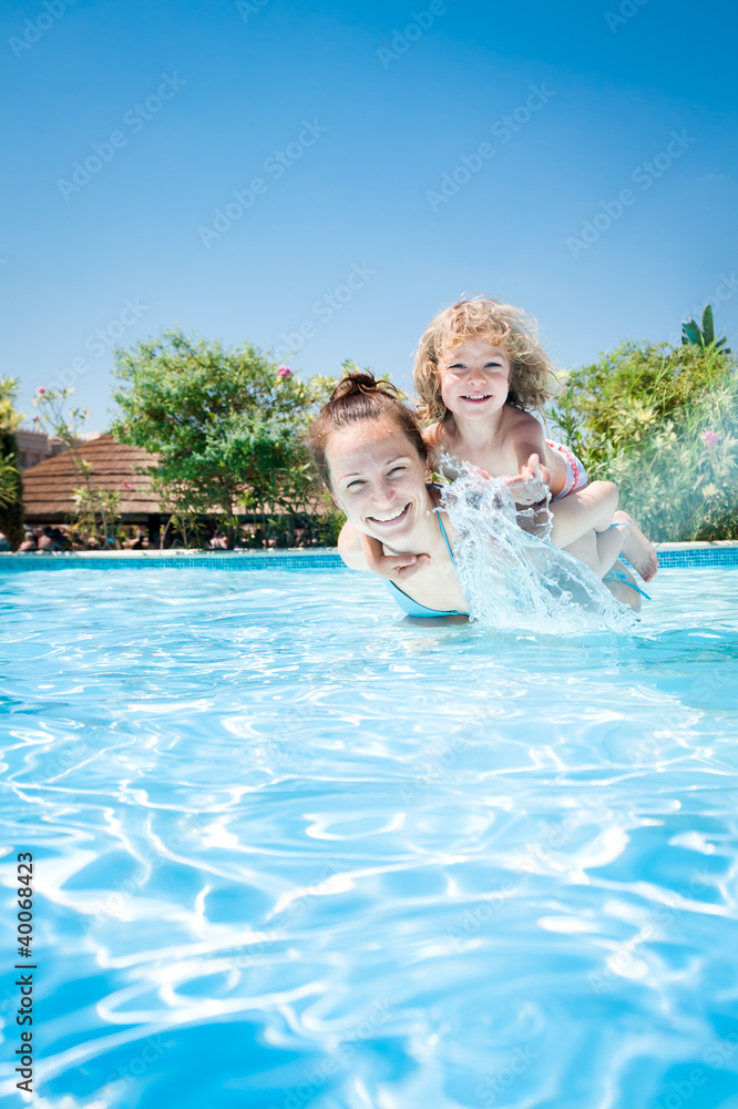 Happy child playing with mother in pool
