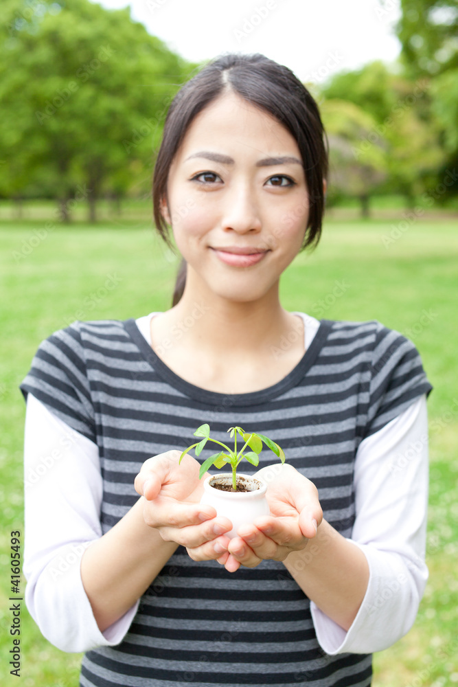 亚洲女人在公园里抱着小植物