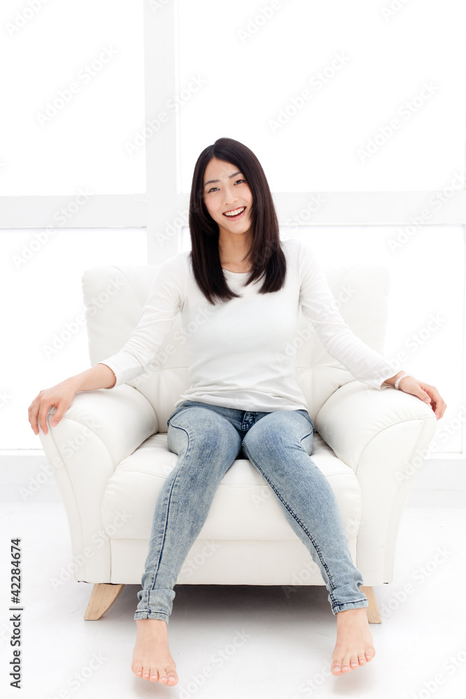 一个年轻的亚洲女人在白色房间里放松