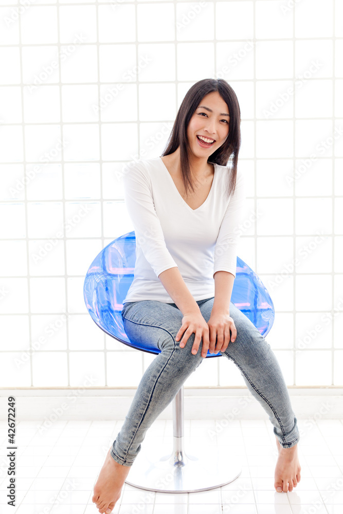 一位坐在蓝色椅子上的年轻亚洲女性