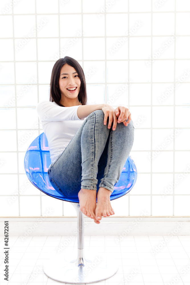 一个坐在蓝色椅子上的年轻亚洲女人