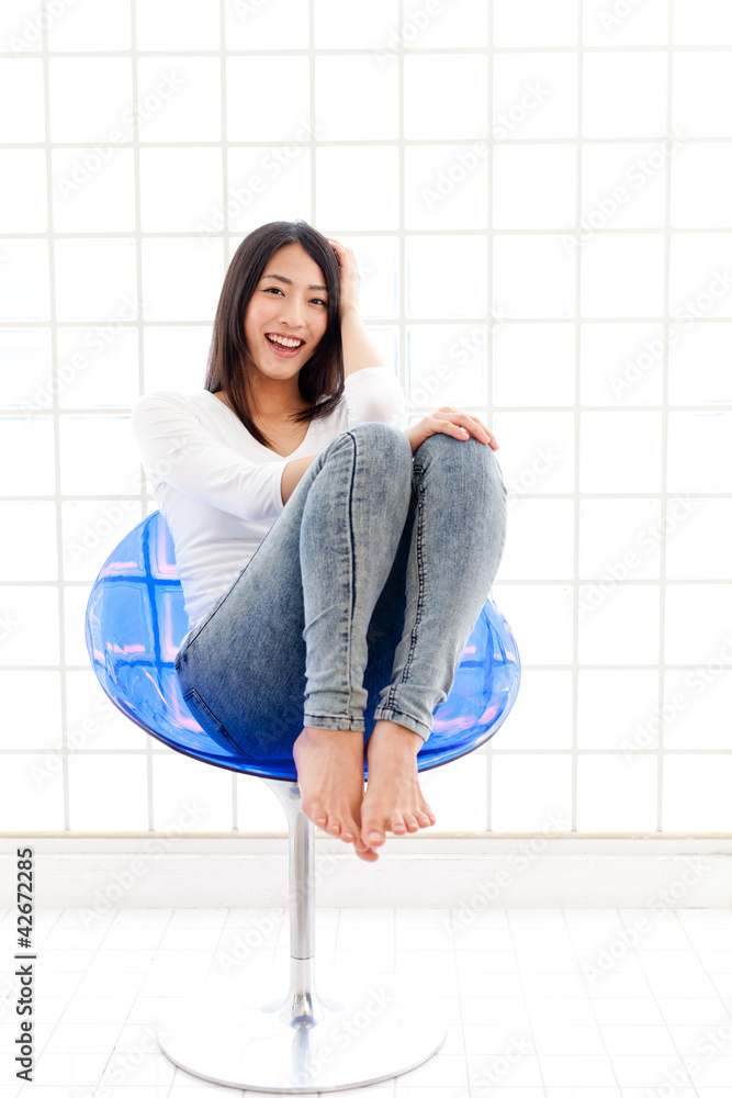 a young asian woman sitting on blue chair